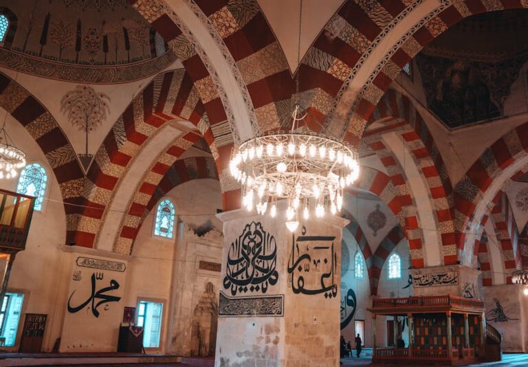 Stunning interior view of a mosque with ornate arches and religious calligraphy.